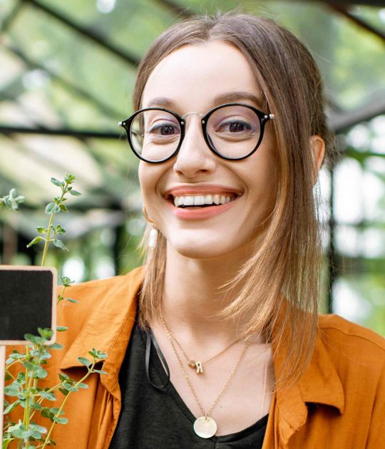 woman-with-herbs-and-flowers-in-the-greenhouse-BET5TYF.jpg